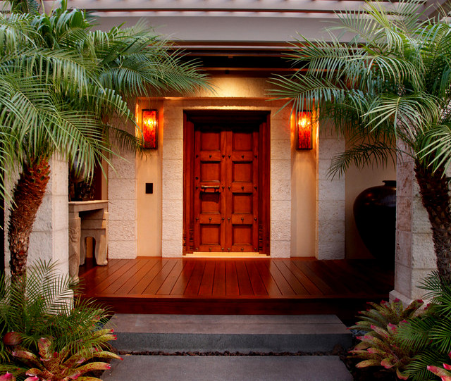 front door with sconces and palm trees 