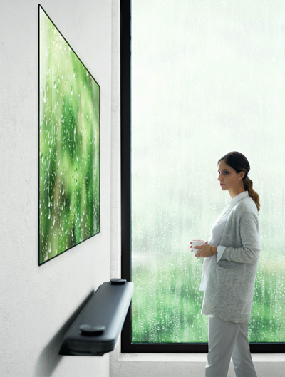 Woman looks at a flat-panel OLED TV