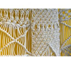Macrame wall hanging in white on a yellow background from Gold Leaf Design Group 