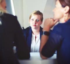 Stock photo of two women interviewing a third woman