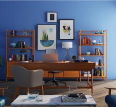 Living room space with blue wall, framed wall art, herringbone flooring and wooden shelving