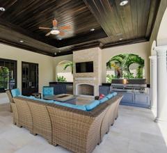 Outdoor kitchen and dining space with fireplace designed by Tres Jolie Maison