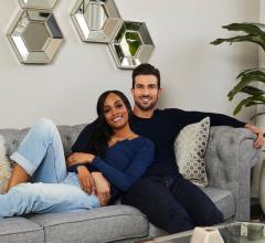 The Bachelorette’s Rachel Lindsay and her fiancée Bryan Abasolo sit on sofa