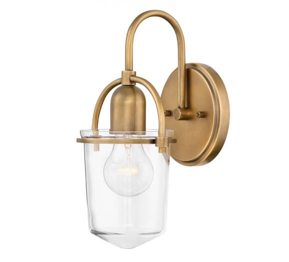 The Clancy wall sconce from Hinkley Lighting measures just 6 by 11.3 inche. Made of steel and clear glass, ideal for an Edison bulb. Available in five finishes, shown here in Heritage Brass. with Heritage brass backplate and arm and clear glass surrounding the bulb from Hinkley Lighting