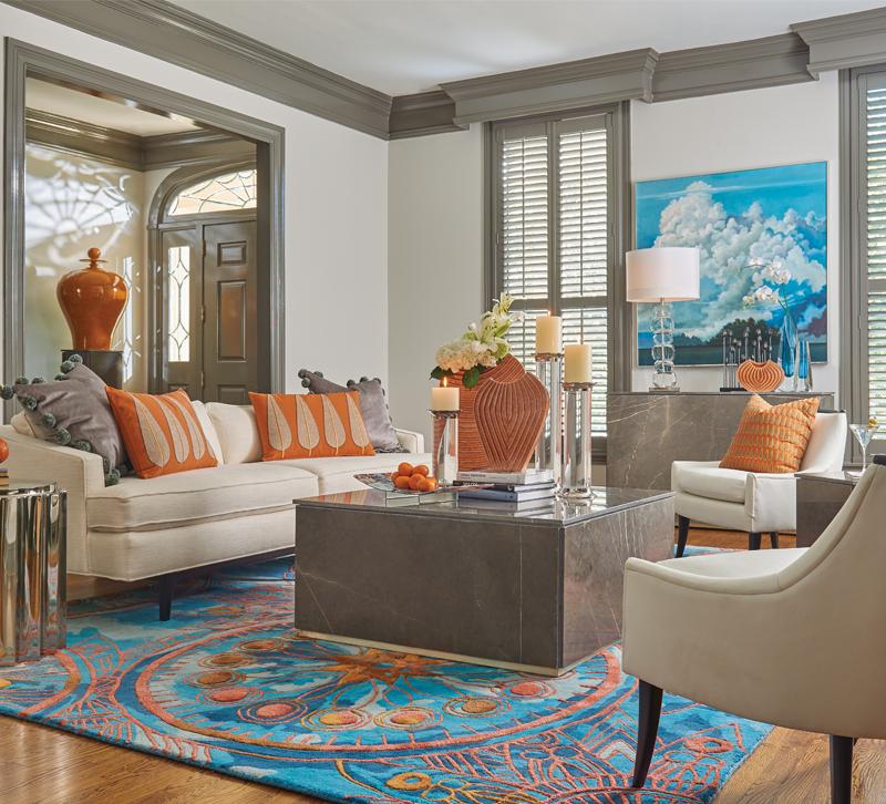 LIving room with beige couch and chairs and blue and orange rug by Global Views