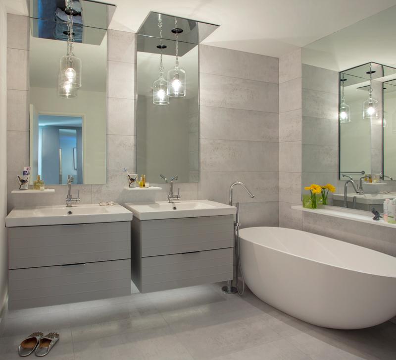 Gray bathroom with two floating vanities and a soaking tub