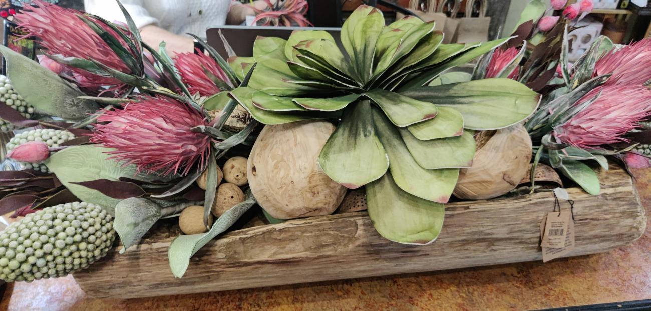 green and pink botanicals in a horizontal wooden holder