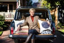 Kerrie Kelly sits on the back of her car with a few of her favorite products
